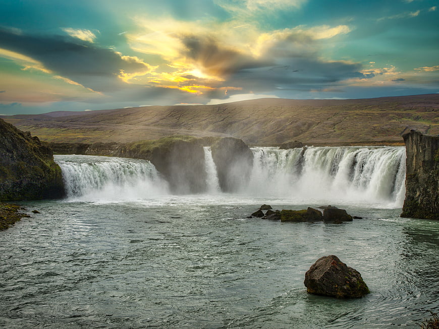 Dramatic Sunset Over Powerful Waterfall in Iceland