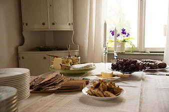 Homemade Cheese Platter with Grapes and Crackers on Dining Table