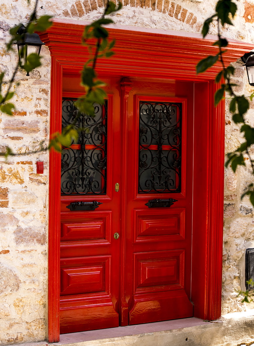 Vibrant Red Wooden Double Door in Stone Wall