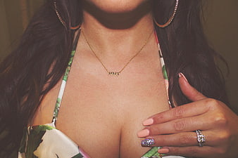 Close-up of woman wearing gold necklace and floral top