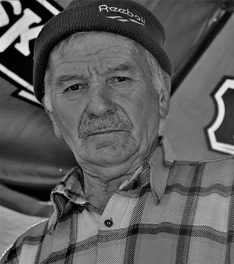 Black and white portrait of elderly man with mustache and beanie