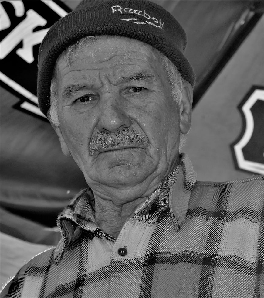 Black and white portrait of elderly man with mustache and beanie