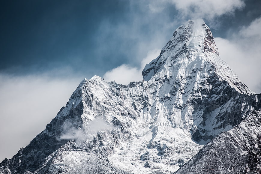 Majestic Snow-Capped Mountain Peak with Dramatic Clouds