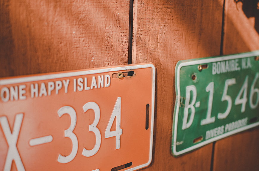 Vintage License Plates on Wooden Wall Background