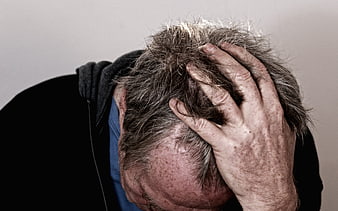 Senior man holding head in despair and frustration