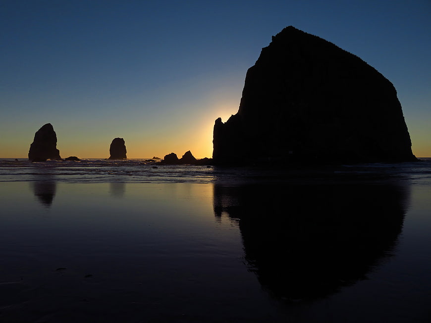 Silhouetted Sea Stacks at Sunset on Wet Beach
