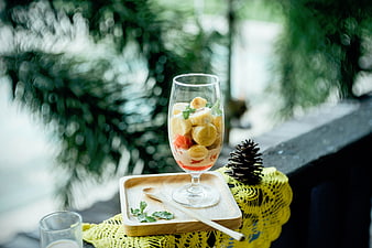 Fresh banana and strawberry dessert in a glass on a wooden tray