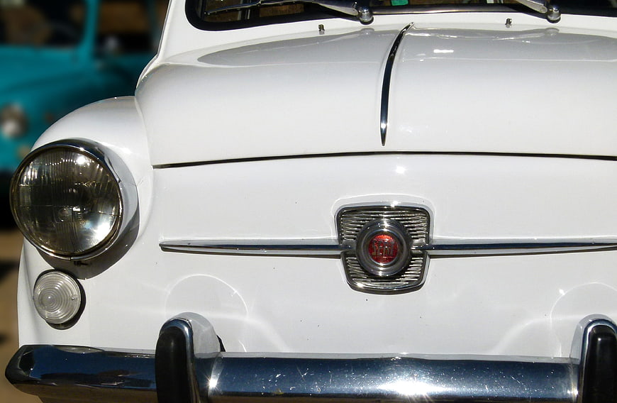 Close-up of vintage white Fiat 600 front grille and headlight