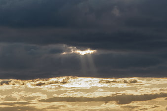 Dramatic Sunbeams Breaking Through Dark Storm Clouds