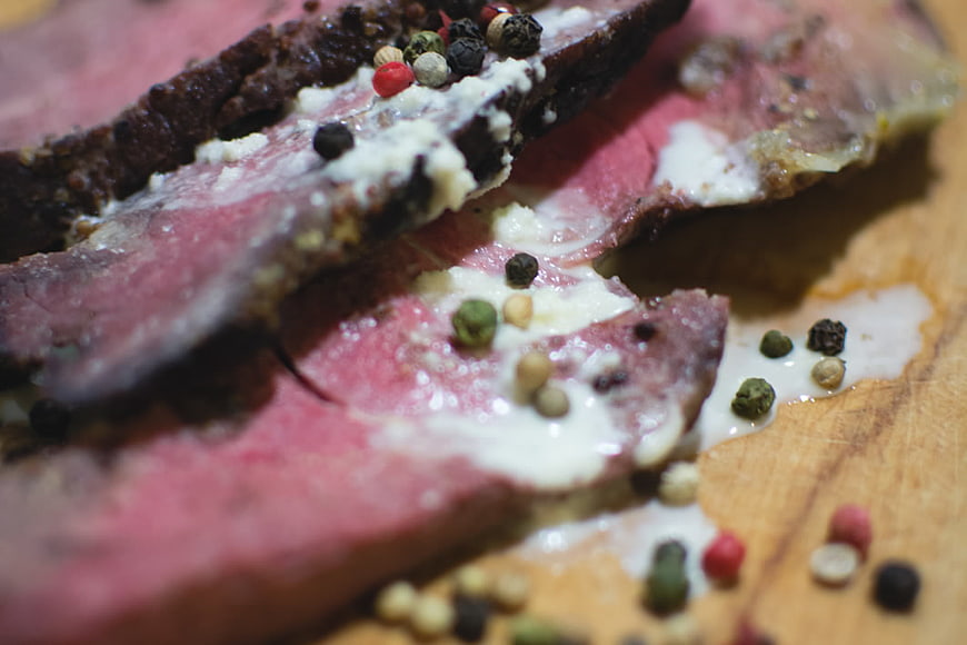 Close-up of sliced peppered roast beef with melted butter