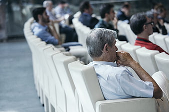 Senior man listening attentively at a conference