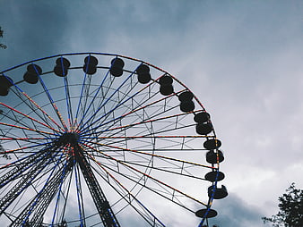 Ferris Wheel Silhouette Against Cloudy Sky