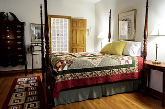Traditional Bedroom Interior With Antique Four-Poster Bed And Patchwork Quilt