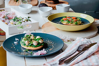 Healthy avocado toast with quail eggs and microgreens on rustic table