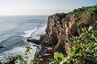Dramatic Coastal Cliff Landscape with Ocean Waves and Green Foliage