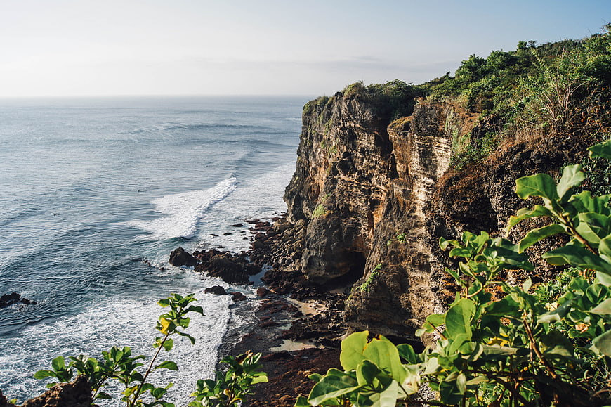 Dramatic Coastal Cliff Landscape with Ocean Waves and Green Foliage