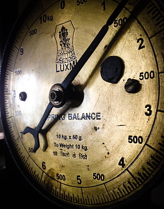 Close-up of vintage brass spring balance scale dial