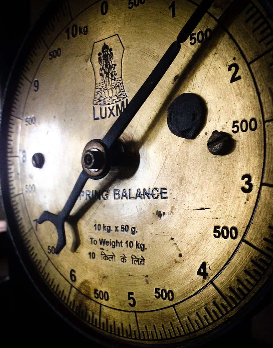 Close-up of vintage brass spring balance scale dial
