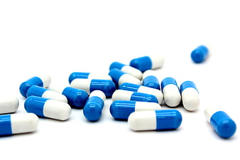 Blue and white medicine capsules on white background