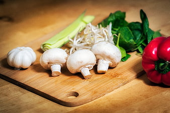 Fresh Vegetables and Mushrooms Arranged on a Wooden Cutting Board