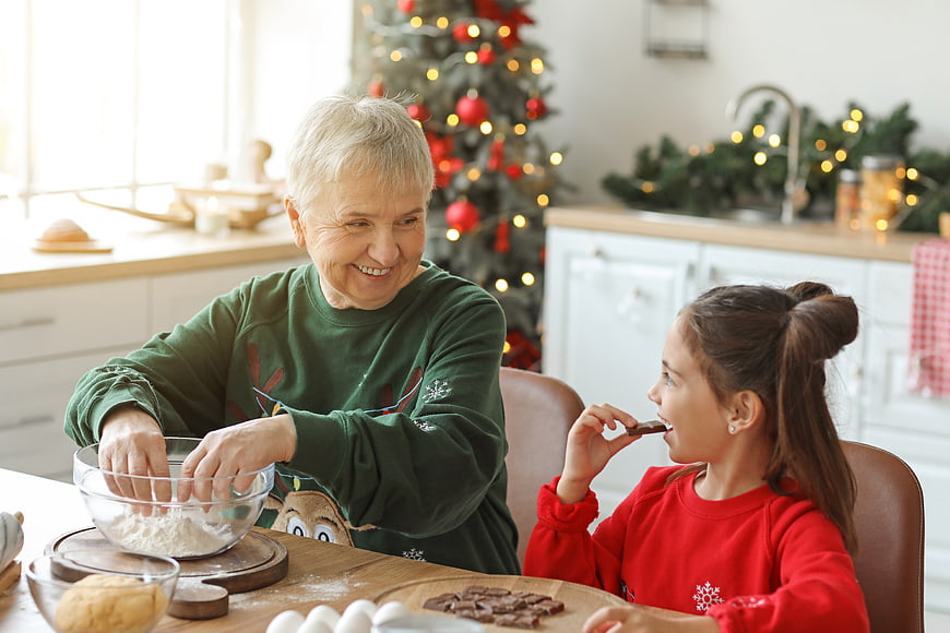 Grandmother and granddaughter baking Christmas cookies in kitchen