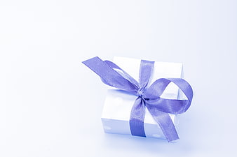 White Gift Box with Purple Ribbon on White Background