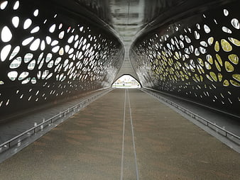 Modern perforated metal bridge tunnel with leading lines