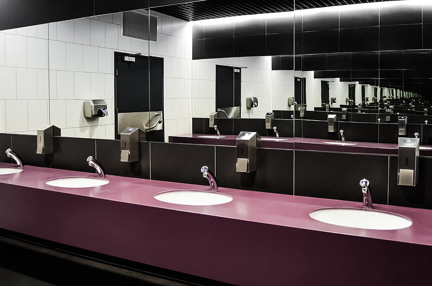 Modern Public Bathroom with Purple Countertop and Mirrors