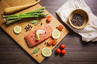 Fresh Salmon Fillet with Asparagus and Lemon on Wooden Board