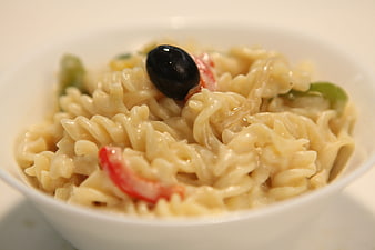 Creamy fusilli pasta salad with black olive and vegetables