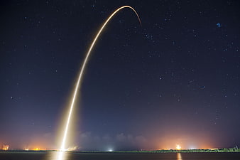 Rocket Launch Trajectory Arc Against Starry Night Sky