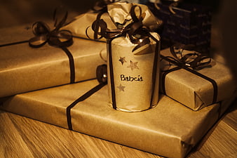 Christmas gifts wrapped in gold paper with ribbons