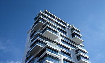 Modern White High-Rise Apartment Building Against Blue Sky