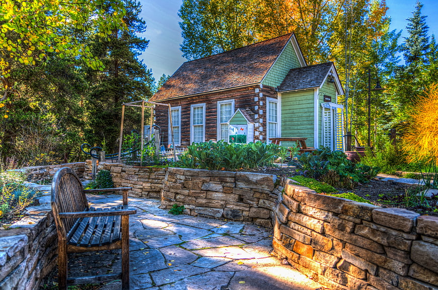 Rustic Log Cabin Garden With Stone Walls And Wooden Bench