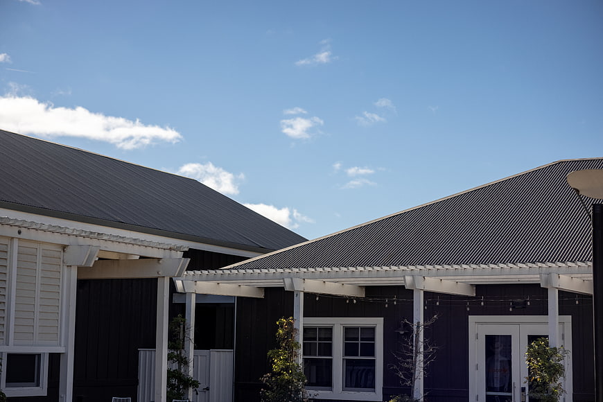 Modern Black House Exterior with Metal Roof and Blue Sky