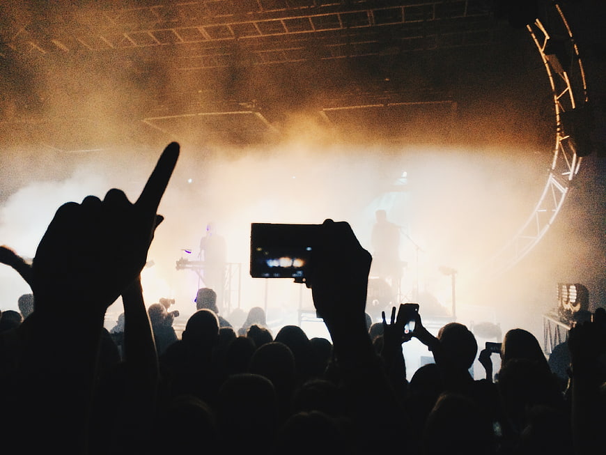 Silhouetted crowd recording live concert with smartphones
