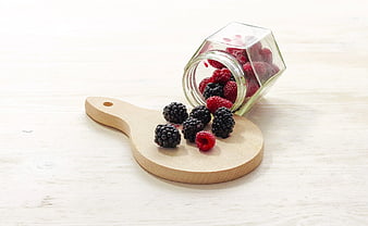 Fresh Raspberries and Blackberries Spilling from Glass Jar