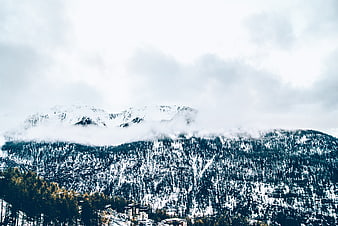 Snowy Mountain Landscape with Clouds and Forest