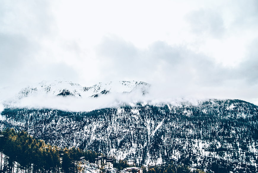 Snowy Mountain Landscape with Clouds and Forest