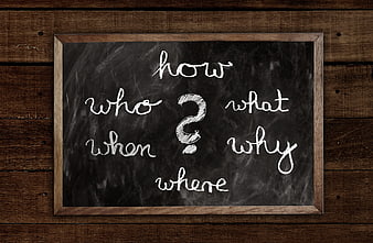 Chalkboard with Question Words on Rustic Wooden Background