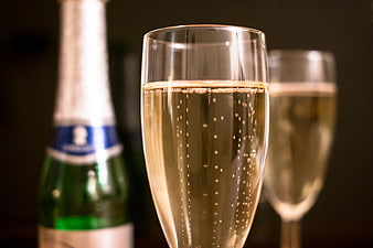 Close-up of champagne glass with bubbles and bottle