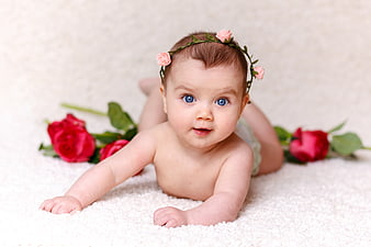 Baby Girl With Floral Crown And Red Roses On White Blanket