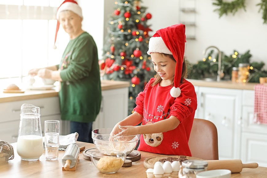 Grandmother and granddaughter baking Christmas cookies in kitchen