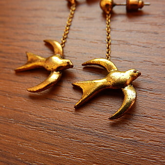 Vintage Gold Swallow Earrings on Wooden Surface