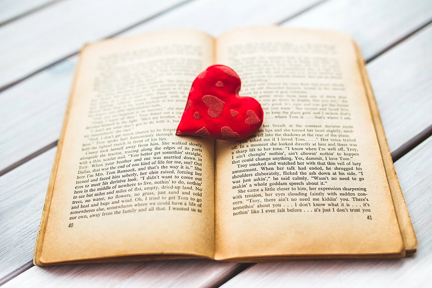 Red heart on open vintage book pages