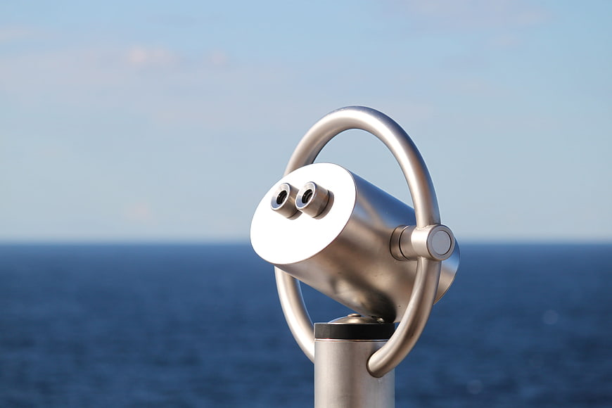 Silver Coin-Operated Binoculars Overlooking Blue Ocean