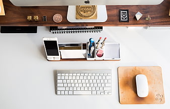Top-down view of organized white office desk with computer and accessories