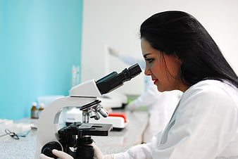 Female scientist using a microscope in a modern laboratory