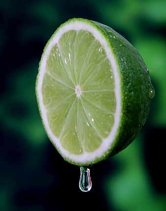 Fresh Sliced Lime with Water Droplet on Green Background