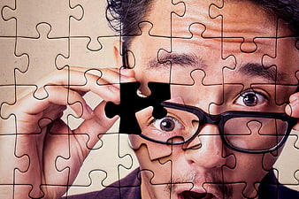 Man with Glasses Holding Missing Puzzle Piece Over Eye
